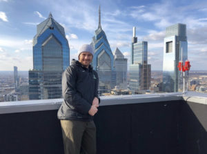 Kevin Crowley posing for a picture in front of the Philly skyline